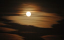 La luna entre barcas de nuves